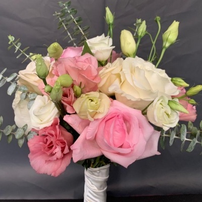 Bouquet de rosas cor de rosa e brancas com folhas verdes e fita branca