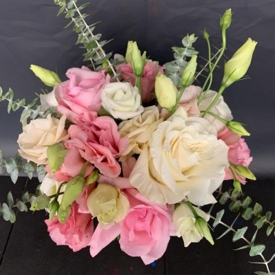 Ramo de flores com rosas e eustomas em rosa, branco e creme com folhagem verde