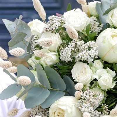 Arranjo floral com rosas brancas e folhas verde-acinzentadas