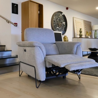 Poltrona reclinável cinza claro em sala moderna com relógio de parede e móveis decorativos