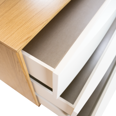 Cômoda de madeira clara com gavetas brancas abertas