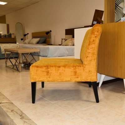 Cadeira amarela mostarda estofada com pernas pretas em loja de móveis