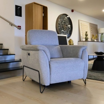 Poltrona cinza claro em tecido com estrutura metálica preta nas pernas num ambiente interior moderno