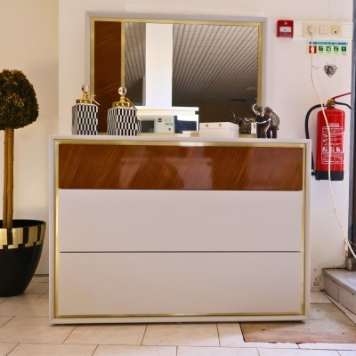 Cómoda moderna branca com acabamento em madeira castanha, espelho e decoração em cima