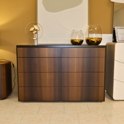 Cómoda de madeira escura com gavetas e decorações em vidro dourado