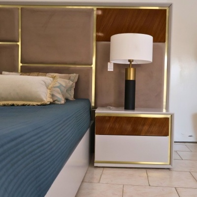 Quarto com cama e mesa de cabeceira com candeeiro