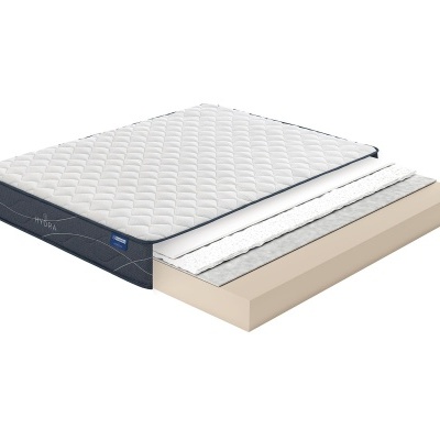 Colchão em corte mostrando camadas internas com capa branca matelassada e laterais cinzentas com etiqueta