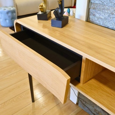 Mesa de madeira clara com gaveta aberta e decoração com objetos em forma de mão