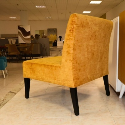 Cadeira amarela estofada com pernas pretas numa loja de móveis