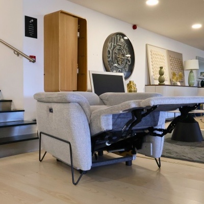 Poltrona reclinável cinza claro com estrutura metálica preta numa sala moderna