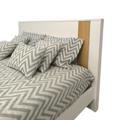 Cama branca com cabeceira de madeira clara e roupa de cama cinza com padrão zig-zag