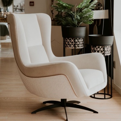 Cadeira branca de descanso com base preta em ambiente interior com plantas