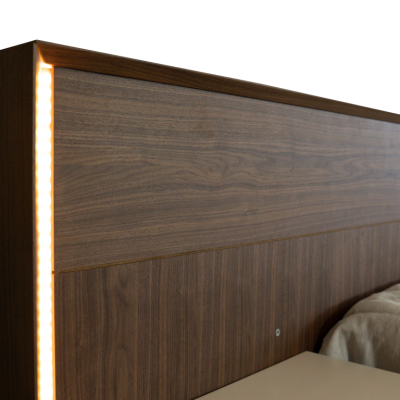 Cabeceira de cama em madeira castanho escuro com iluminação LED embutida na lateral
