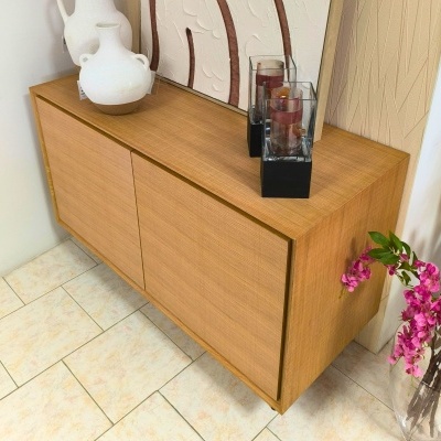 Aparador de madeira com decoração de vasos e velas e flores cor-de-rosa ao lado