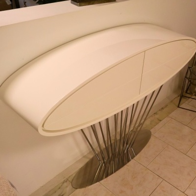 Aparador oval branco com estrutura metálica prateada e base oval