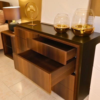 Cómoda madeira com tampo preto, castiçais em vidro dourado, objeto decorativo dourado, mesa com candeeiro azul e base dourada