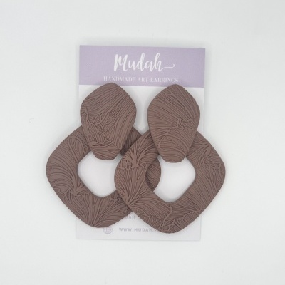 Brincos castanhos texturados em forma de losango com cartão lilás