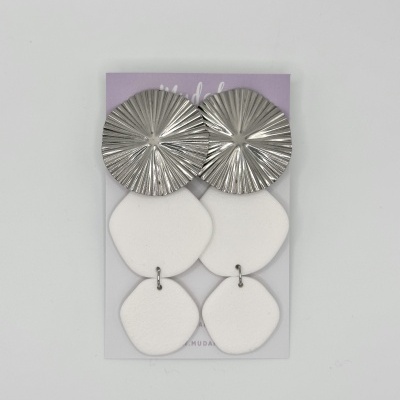 Brincos pendentes com topo metálico prateado texturizado e duas peças brancas foscas em formas geométricas.