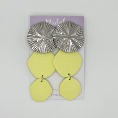 Brincos metálicos prateados e amarelos em cartão lilás