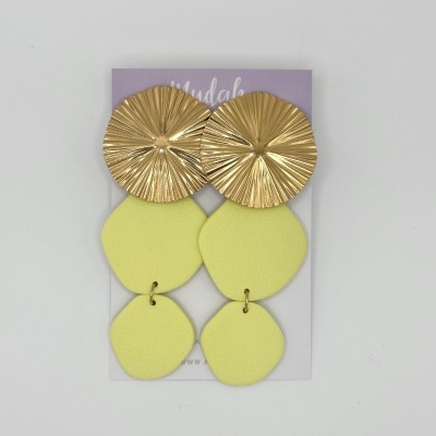 Brincos dourados e amarelos apresentados sobre cartão lilás