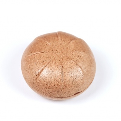 Comprimido redondo castanho claro com estrias sobre fundo branco