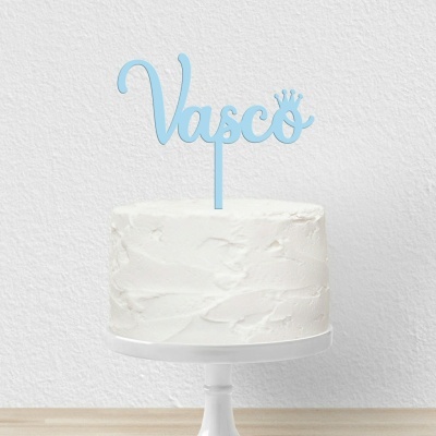 Bolo branco com topper azul com o nome Vasco e coroa sobre suporte branco