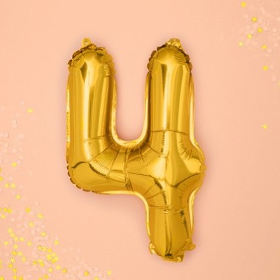 Balão dourado em forma do número 4 num fundo cor de pêssego com confetes.