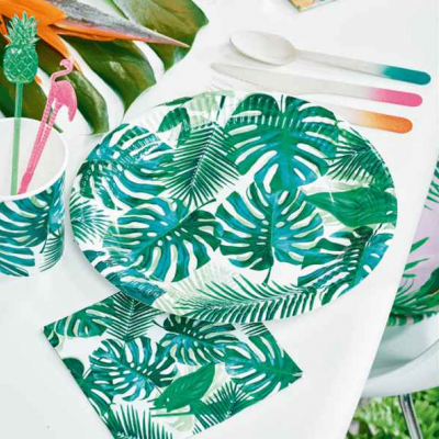 Conjunto de mesa com padrão de folhas verdes tropicais e talheres coloridos.