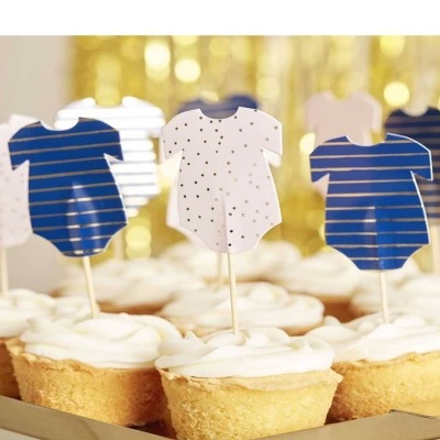Cupcakes decorados com toppers de bodies de bebé em padrões azuis e brancos