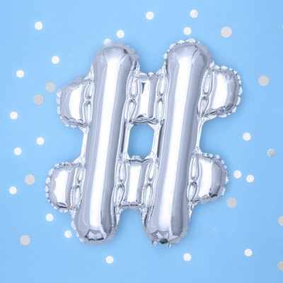 Balão prateado em forma de símbolo de hashtag (#) em fundo azul claro com pequenos círculos