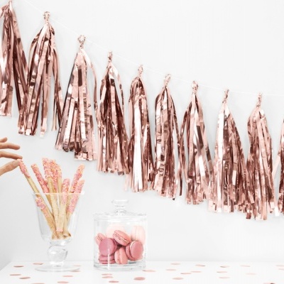 Decoração festiva com franjas metálicas cor de rosa, frasco com macarons e palitos doces coloridos