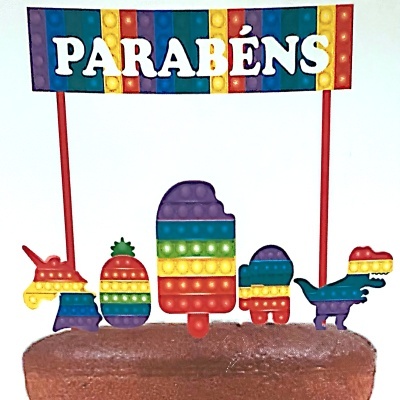 Topo de bolo com figuras coloridas pop it e placa com palavra PARABÉNS