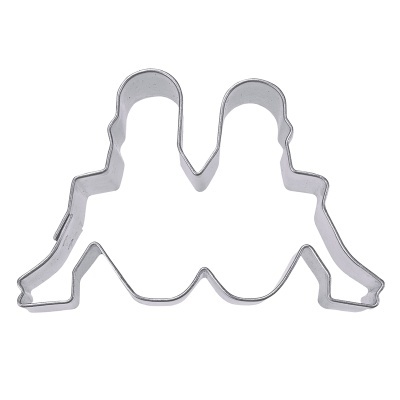 Forma de metal para biscoitos com desenho de duas pessoas sentadas lado a lado.