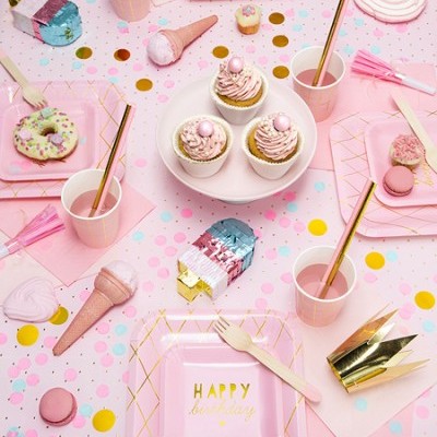 Mesa de festa rosa com pratos e copos descartáveis, cupcakes, doces e confetes coloridos