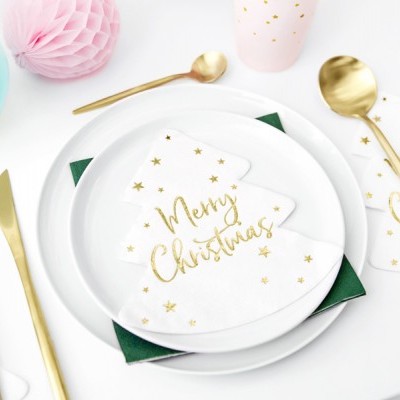 Mesa posta com pratos brancos, guardanapos em forma de árvore de Natal com texto 'Merry Christmas' dourado, talheres dourados e decoração com bolas de papel azul e rosa.