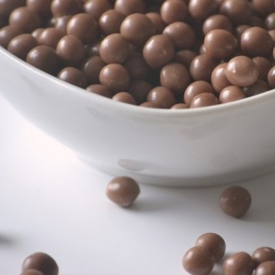 Tigela branca com pequenas esferas de chocolate castanho escuro