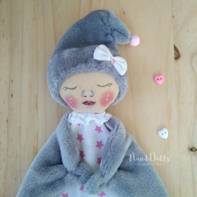 Boneca de tecido cinza com vestido branco e estrelas cor-de-rosa e laço branco na cabeça
