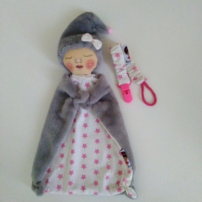 Boneca de pano com vestido branco e estrelas cor-de-rosa e prendedor de chupeta