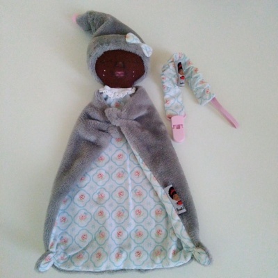 Boneco de tecido cinzento com padrão floral com acessório rosa