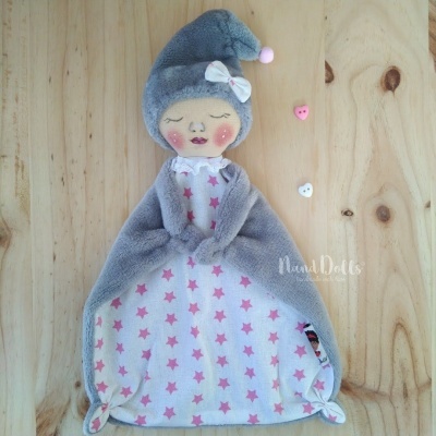 Boneca de pano cinza e branca com vestido de estrelas rosa e chapéu com pompom
