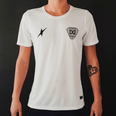 T-shirt branca com símbolos DG e preto no peito, usada por pessoa com tatuagens, fundo preto