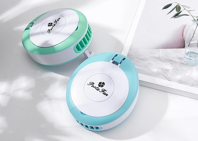 Dois purificadores de ar portáteis redondos verde e azul sobre superfície branca