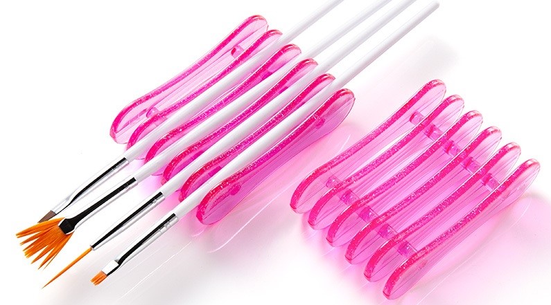 Pincéis para unhas com suportes rosa e fundo branco