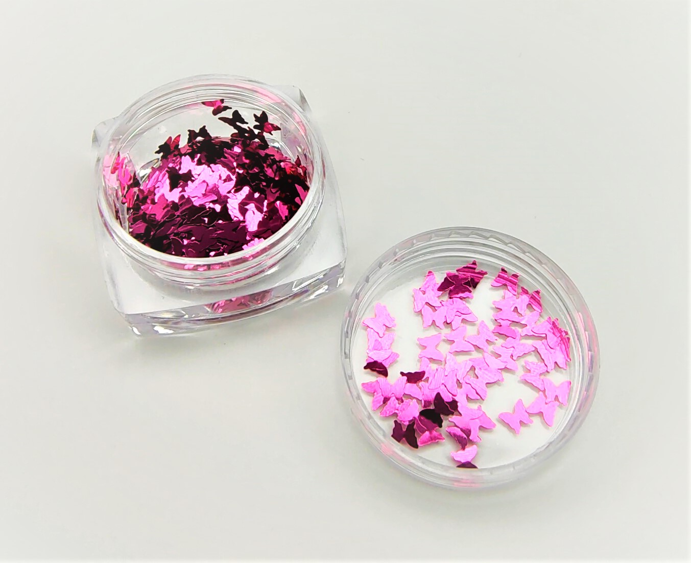 Frascos transparentes com purpurina rosa metálica em forma de borboletas
