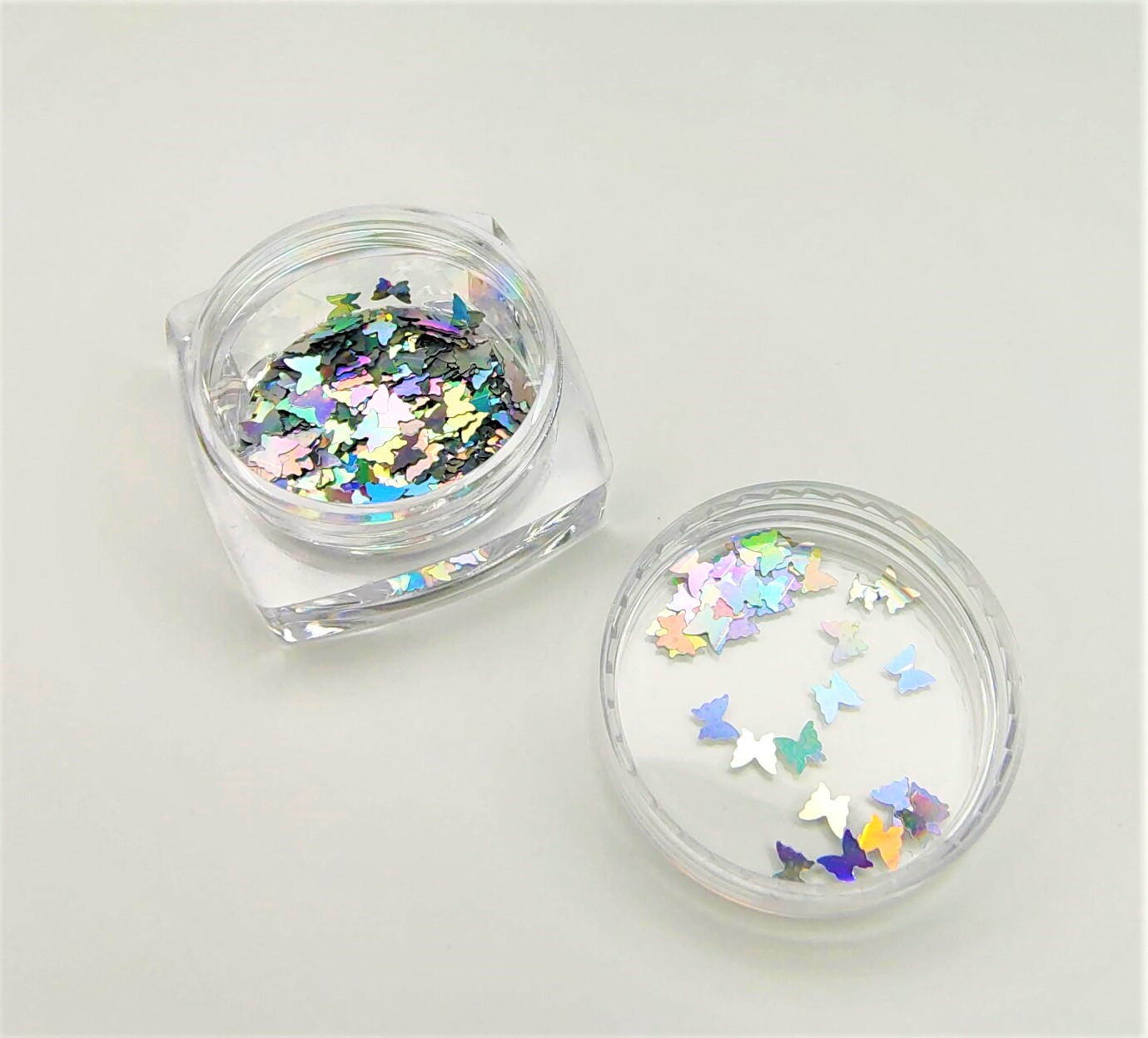 Frasco com confetes holográficos em forma de borboleta aberto