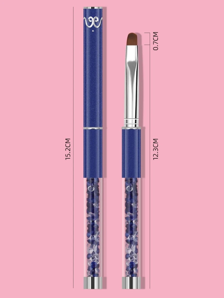 Pincel de cerdas marrons com cabo azul escuro e parte inferior transparente com pedras azuis sobre fundo rosa