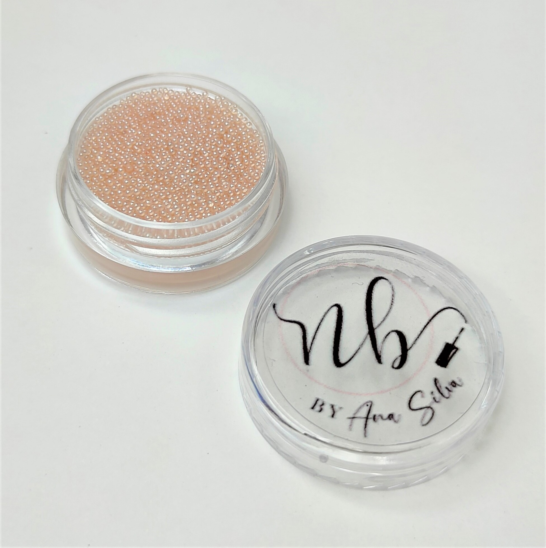 Dois recipientes transparentes com pérolas cor de rosa e tampa com texto nb BY Ana Sílvia