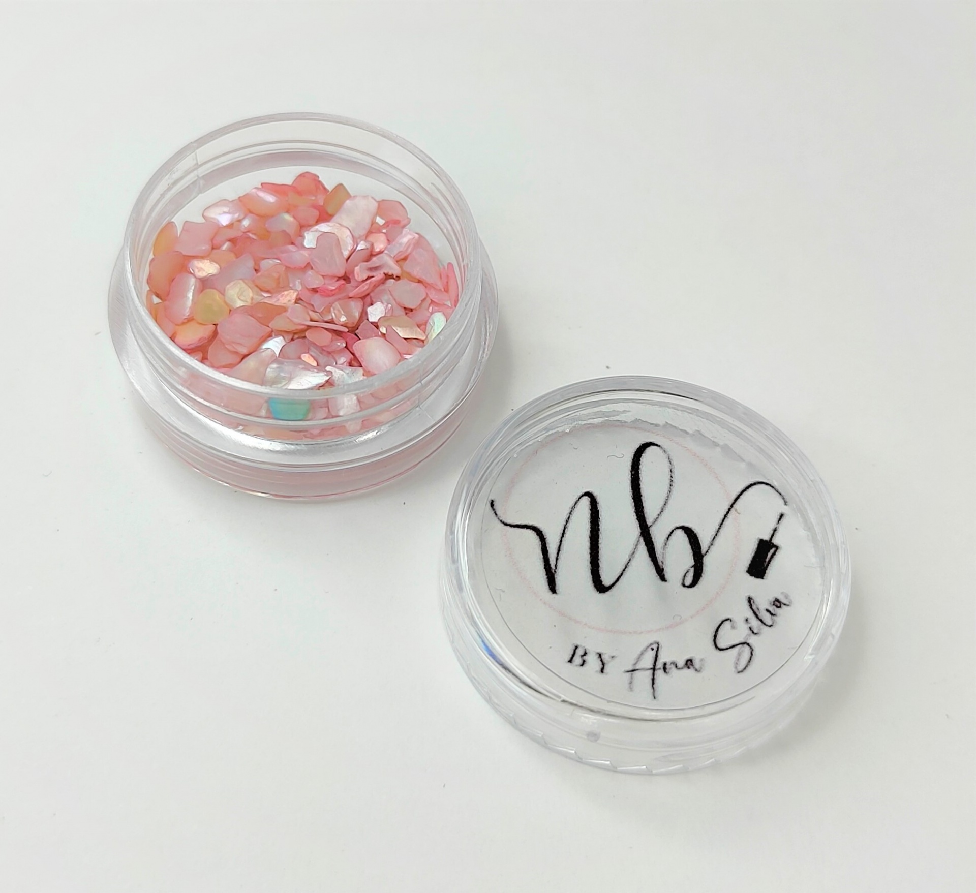 Frasco transparente com pedaços iridescentes coloridos e tampa com texto nbs BY Ana Sólis
