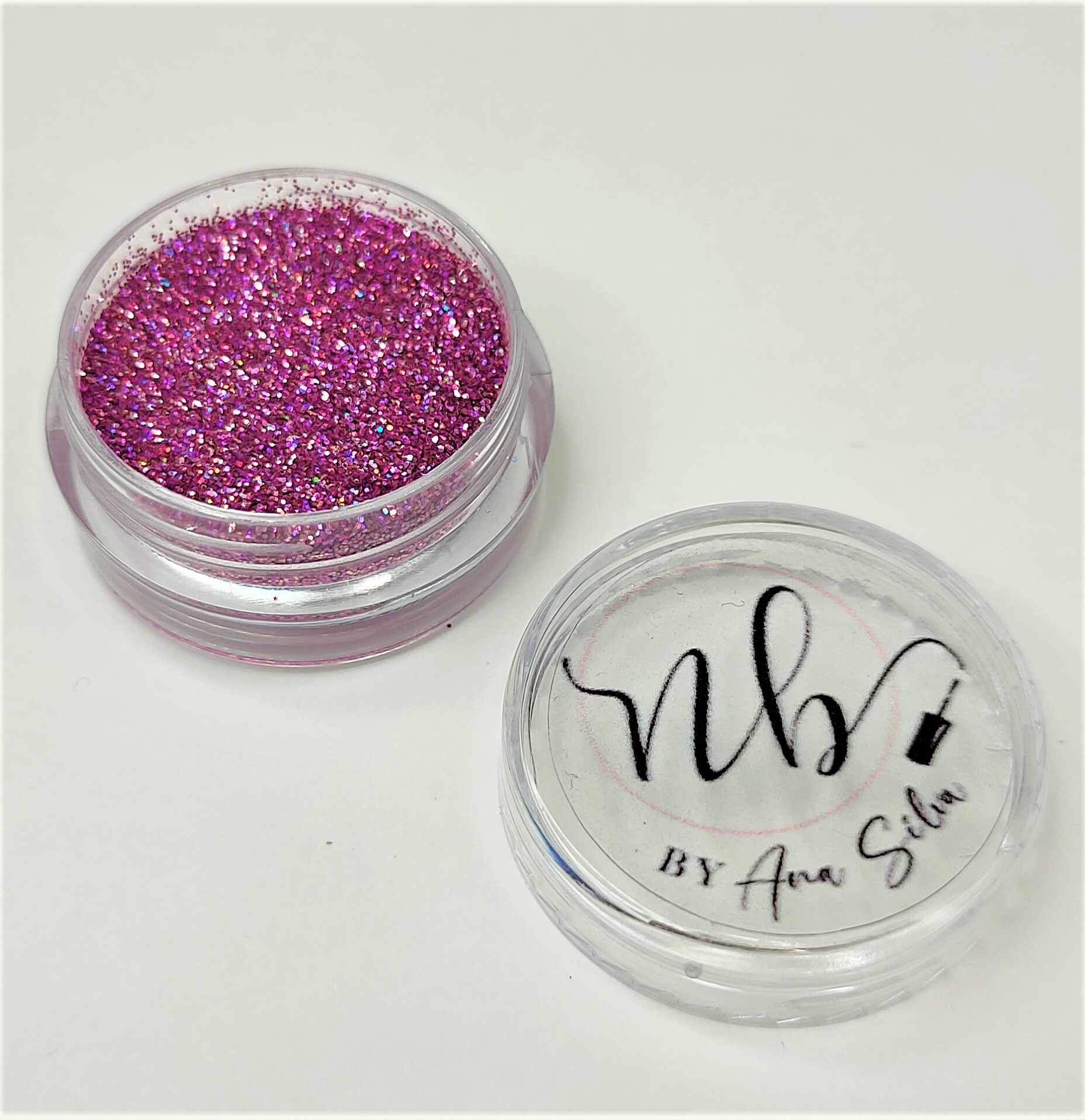 Pote plástico com glitter rosa e tampa com texto 'nby BY Ana Silva'