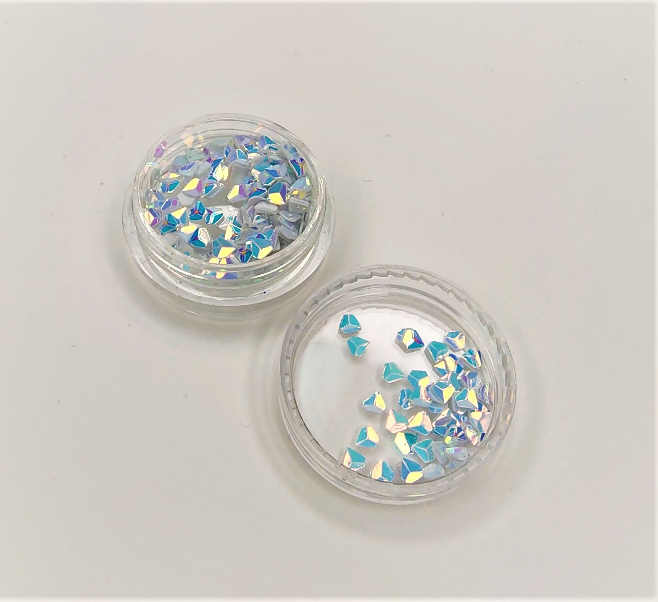 Caixas plásticas com pedaços decorativos holográficos azuis e brancos